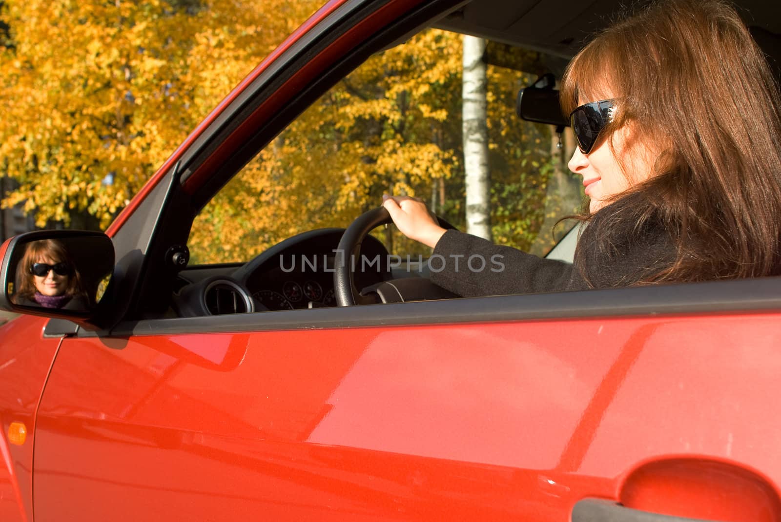 The girl in the red car and her reflection in a mirror