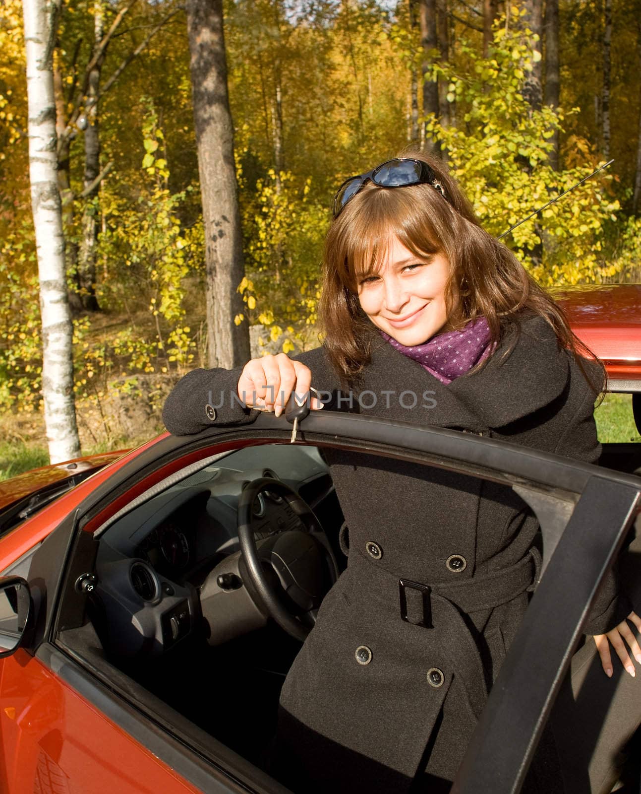 The girl with a key leaves the red car