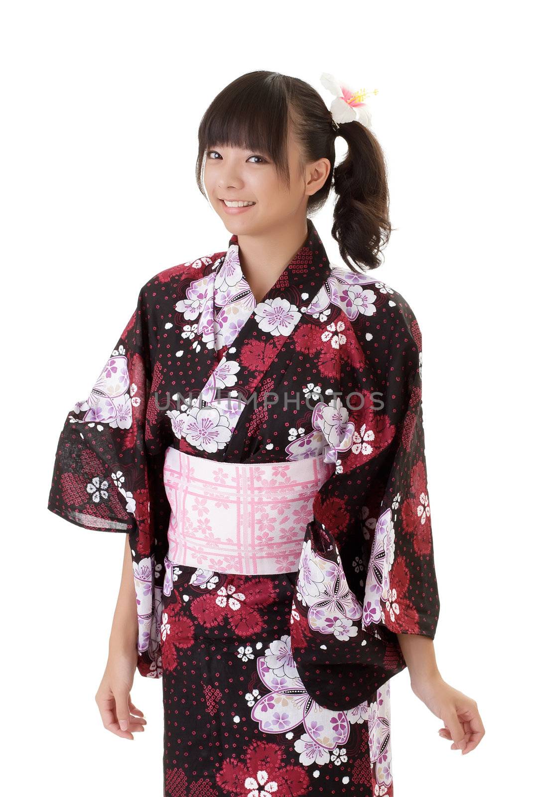 Young Japanese girl smiling in traditional clothes against white.