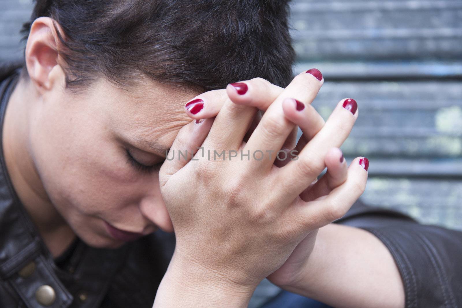 depressed young woman, her face pressed against his hands, his head bent down