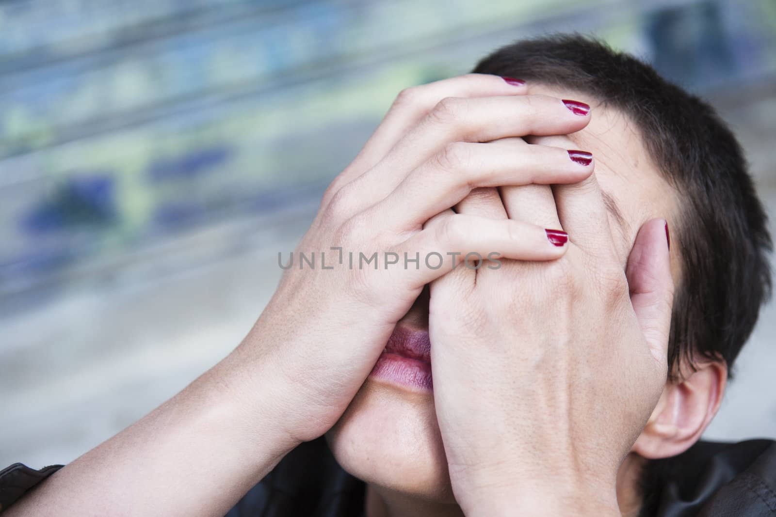 young woman in pain, his head bent back, his face hidden in her hands