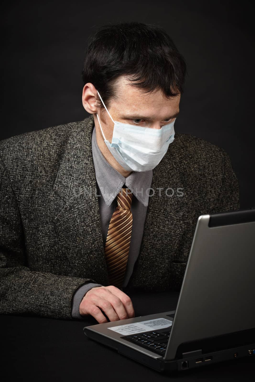 Man in medical mask diagnoses computer by pzaxe