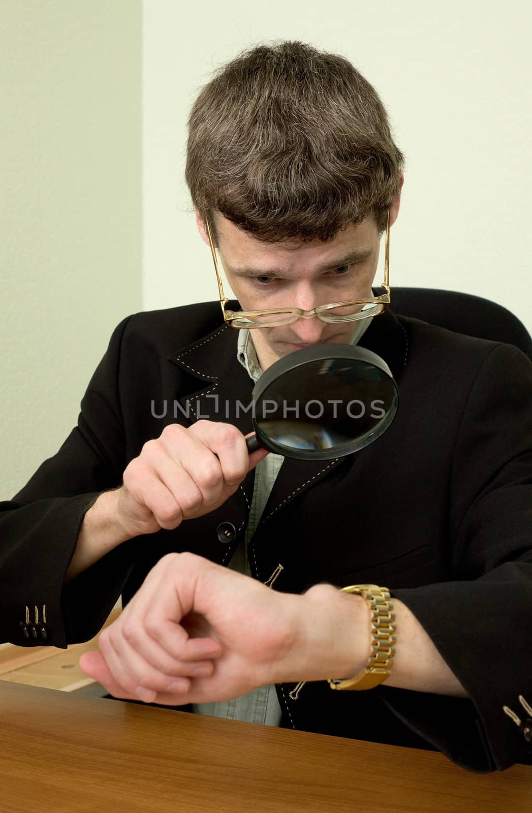 Person examines a watch through a magnifier