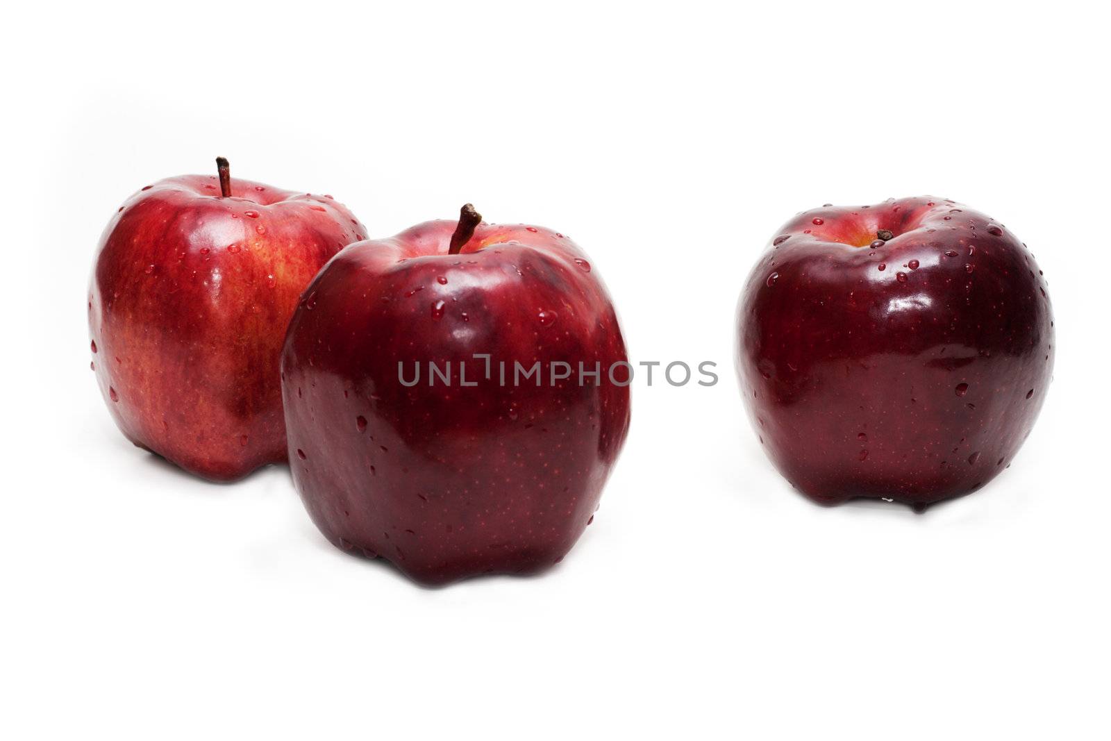 Three red apples, in droplet grow insulated on white background