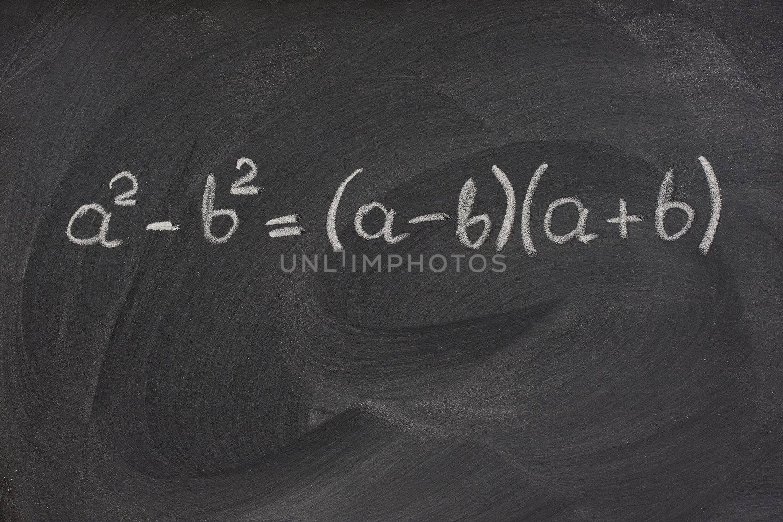 simple mathematical formula handwritten with white chalk on a blackboard with strong eraser smudge patterns
