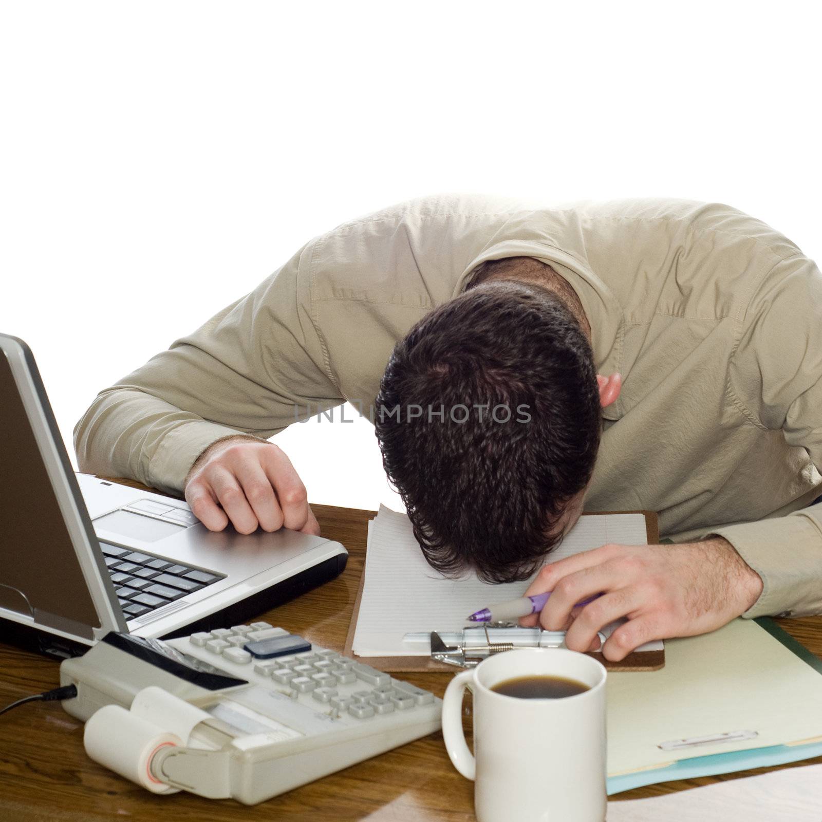 A depressed businessman lying with his head on his desk, isolated against a white background