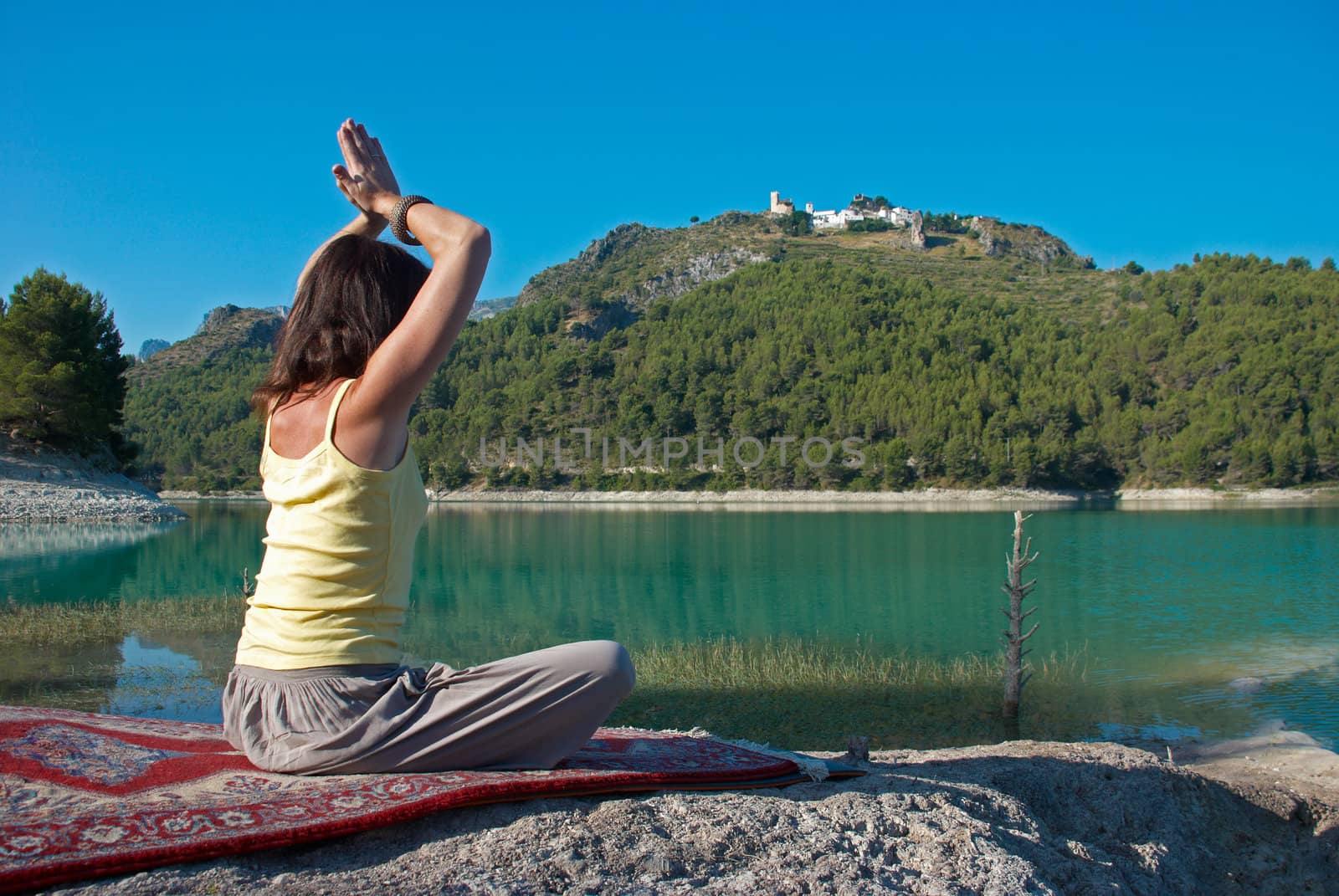 Relaxing with yoga early morning on the shores of a lake