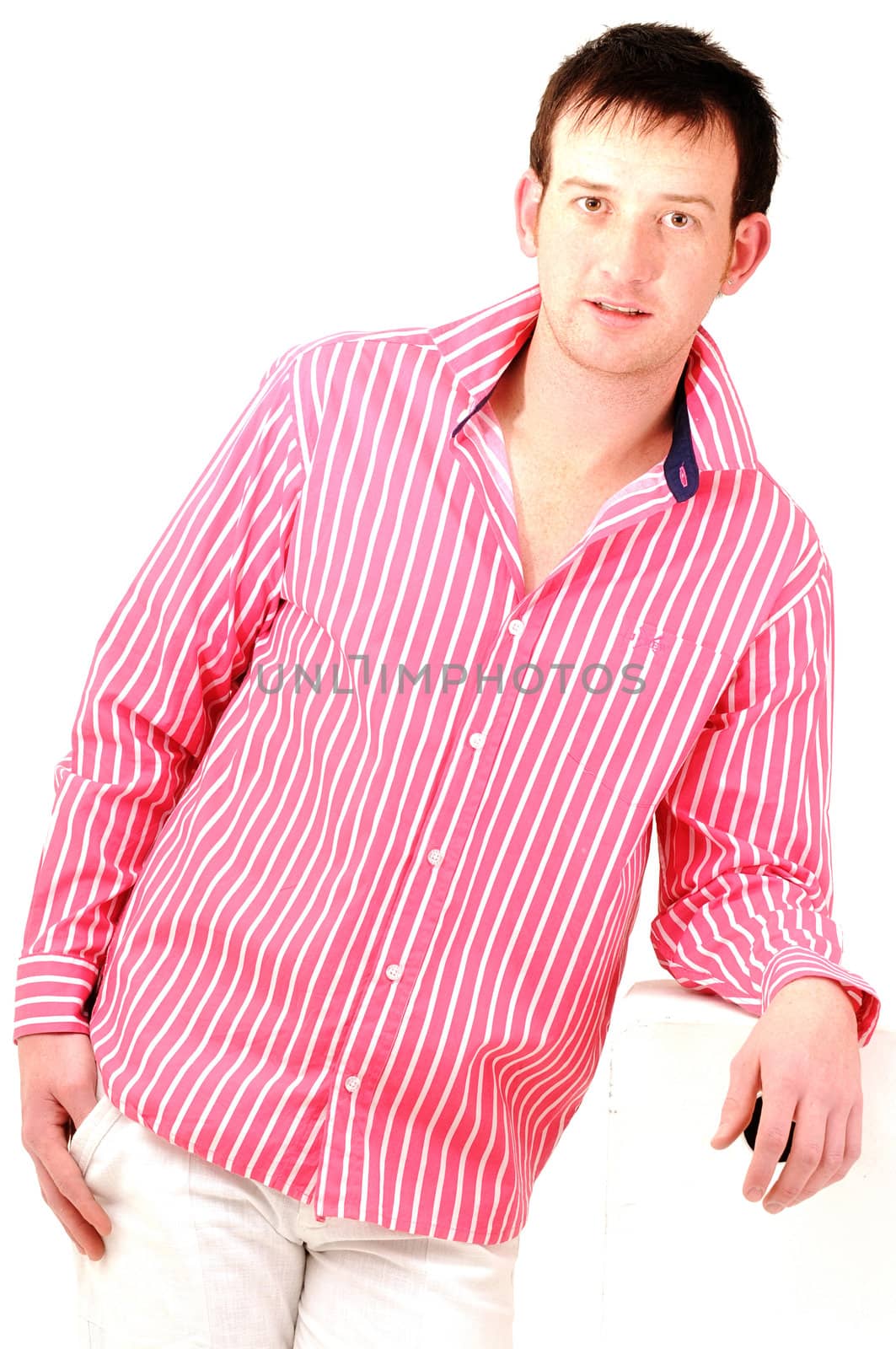 handsome male model leaning on pedestal wearing bright fashionable clothes