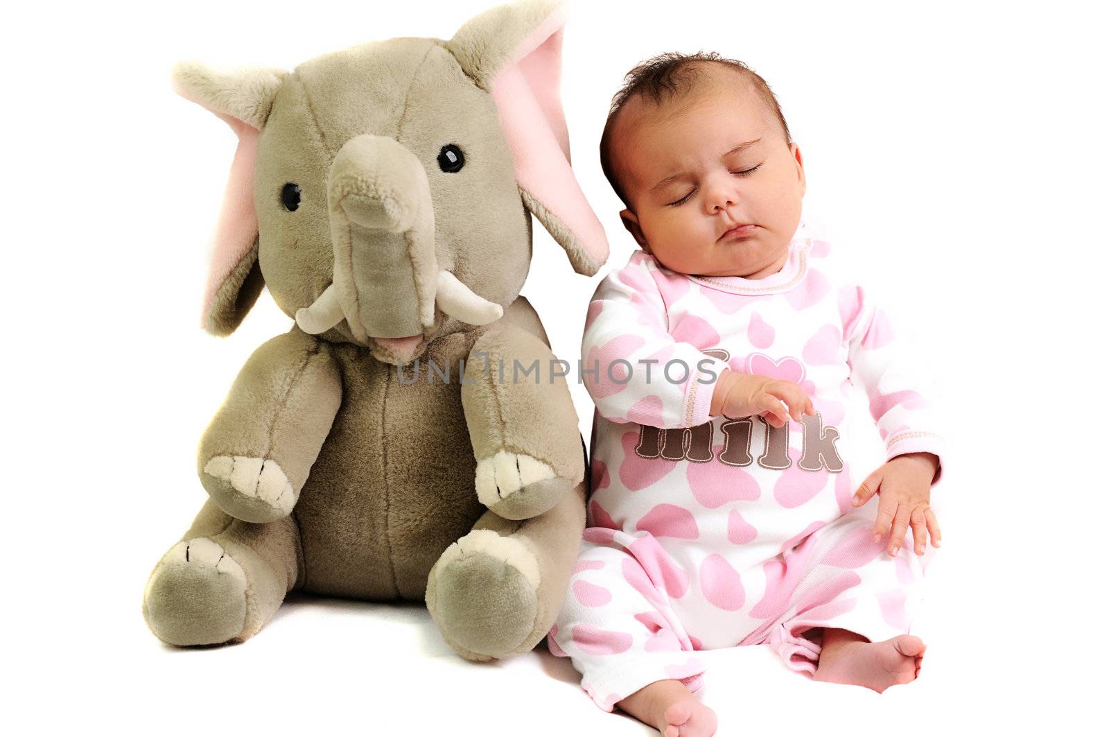 baby girl with pink dots suite sitting and sleeping with grey elephant toy next to her