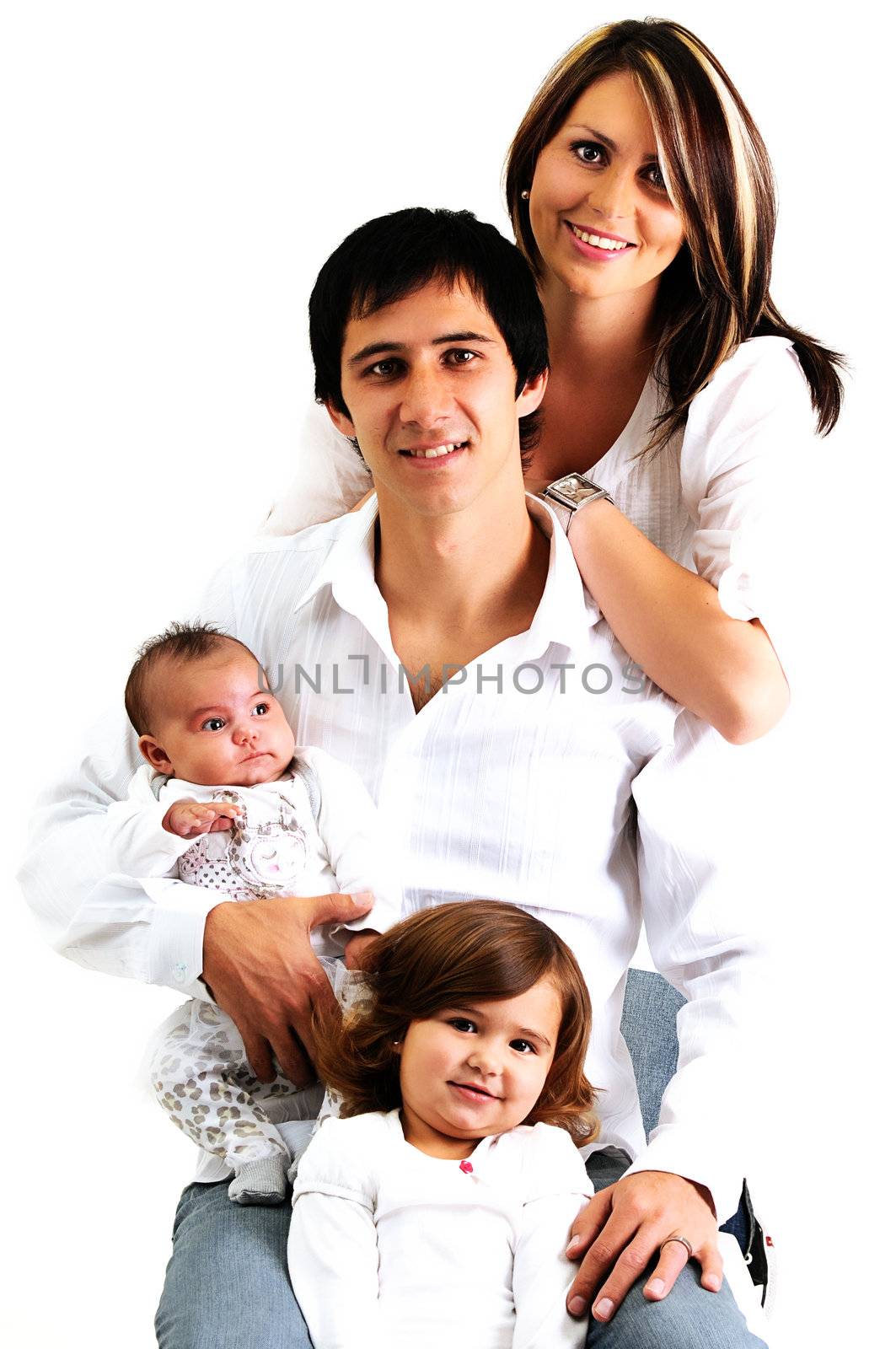 portrait of a young family with their newborn baby and daughter smiling