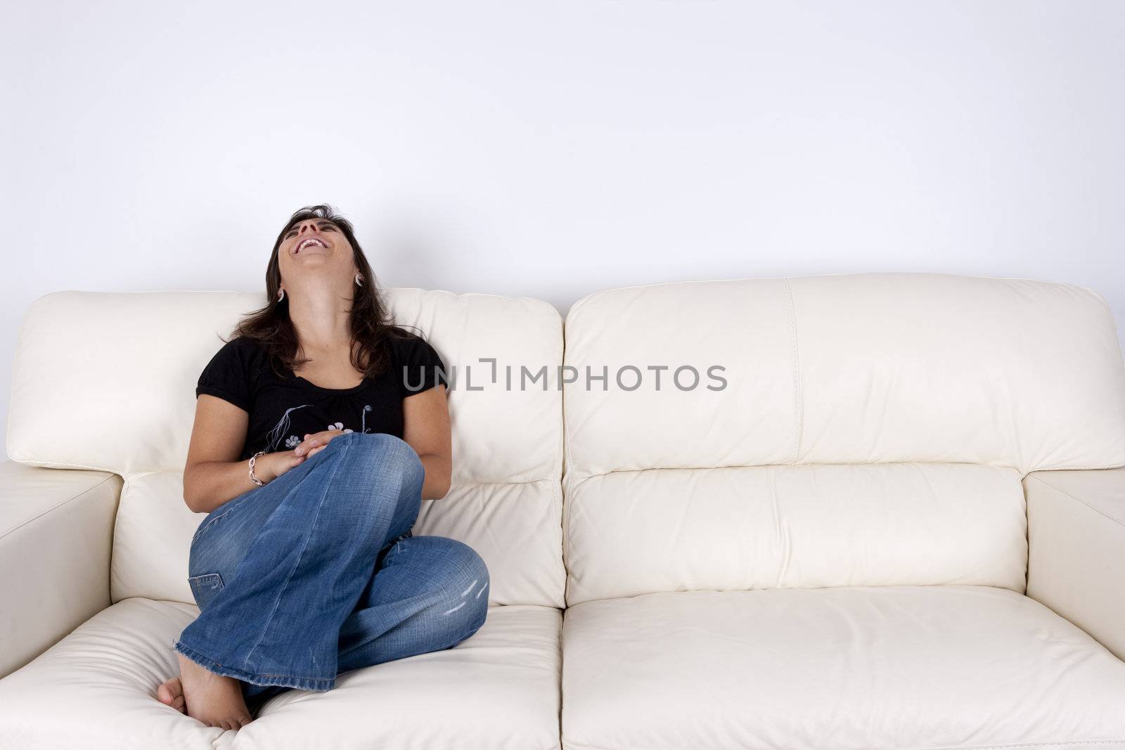 beautiful young woman sitting in white sofa smiling by mlopes