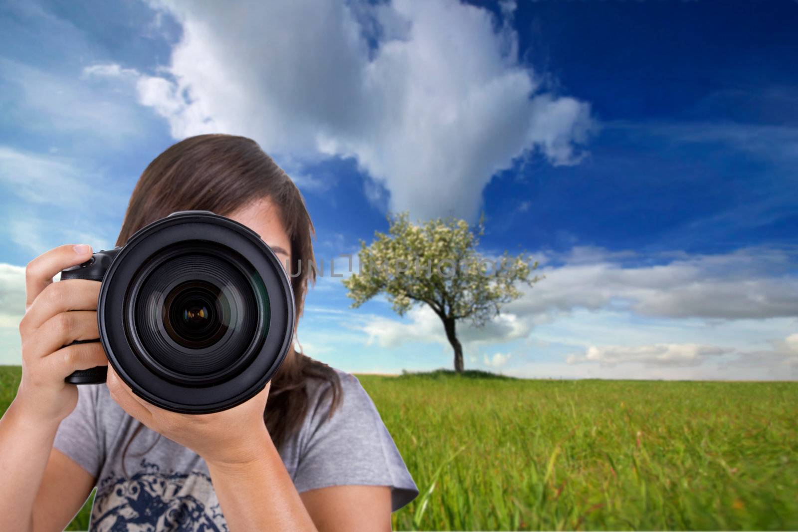 young female photographer with digital photo camera shotting landscape scene