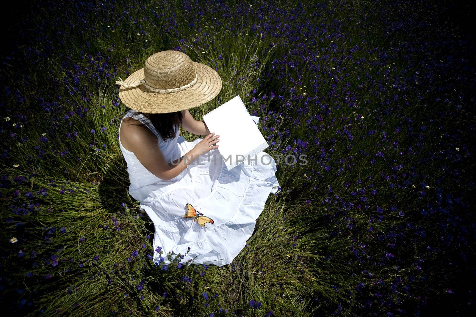 young woman in white dress reading book outdoors by mlopes