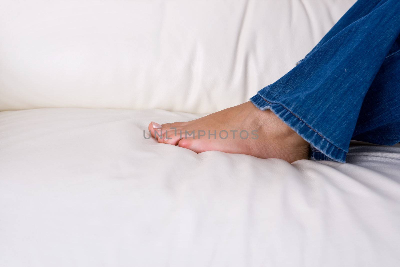 young woman resting in sofa with bare feet