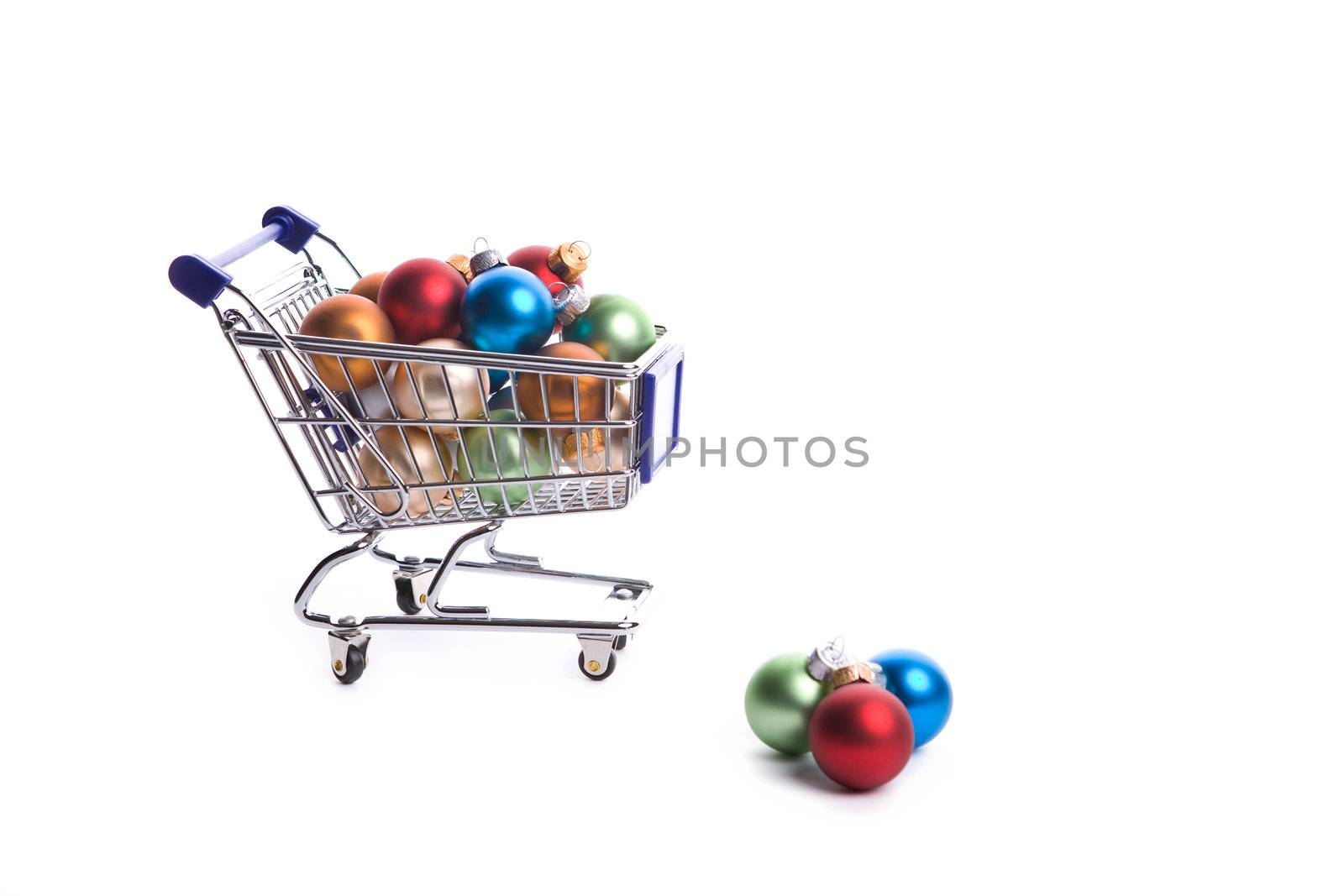 shopping cart full with christmas balls isolated on white background