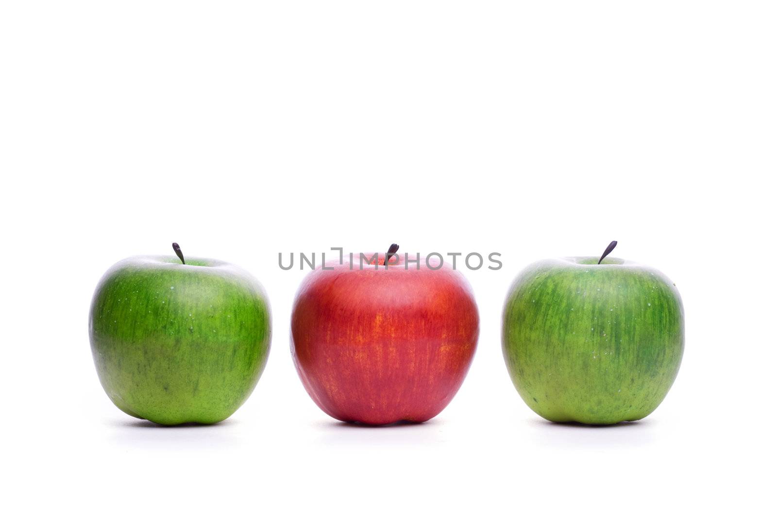 red apple beetween green apples isolated on white background