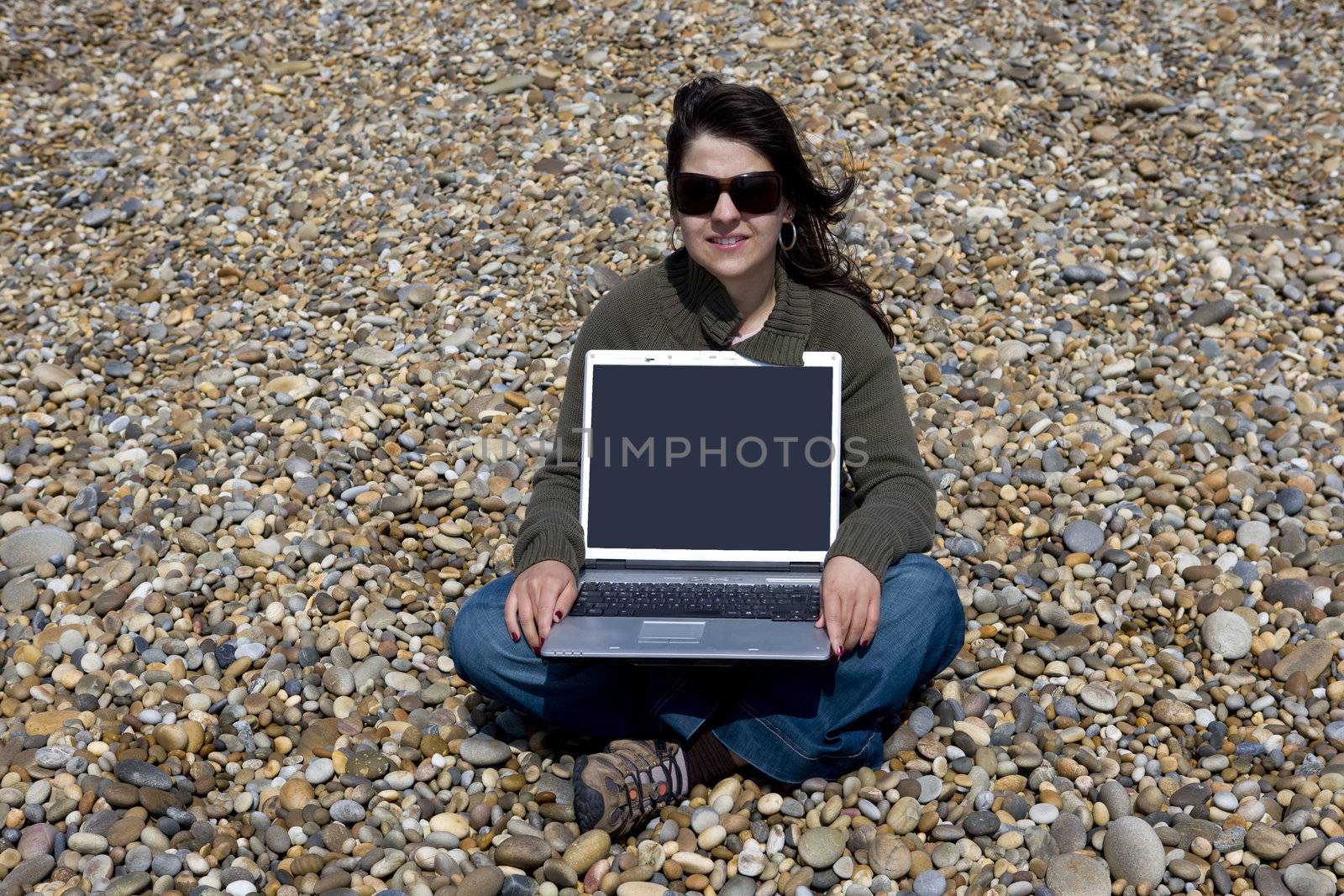 young woman with laptop computer in beach by mlopes