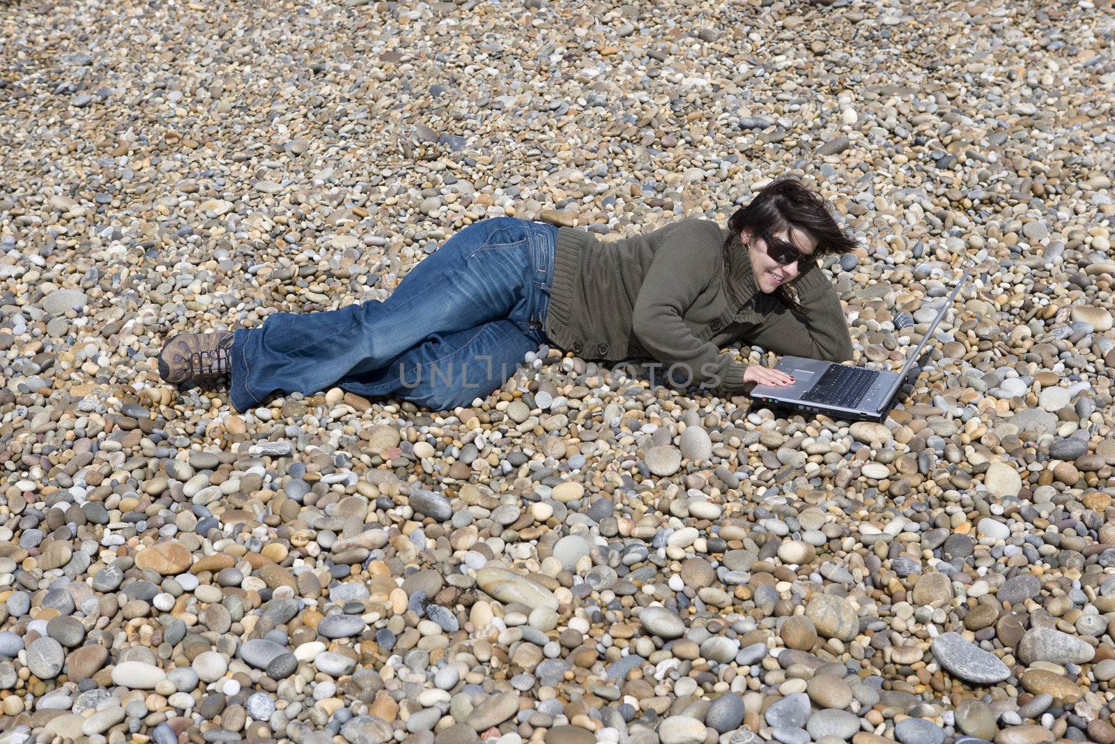 young woman with laptop computer in beach