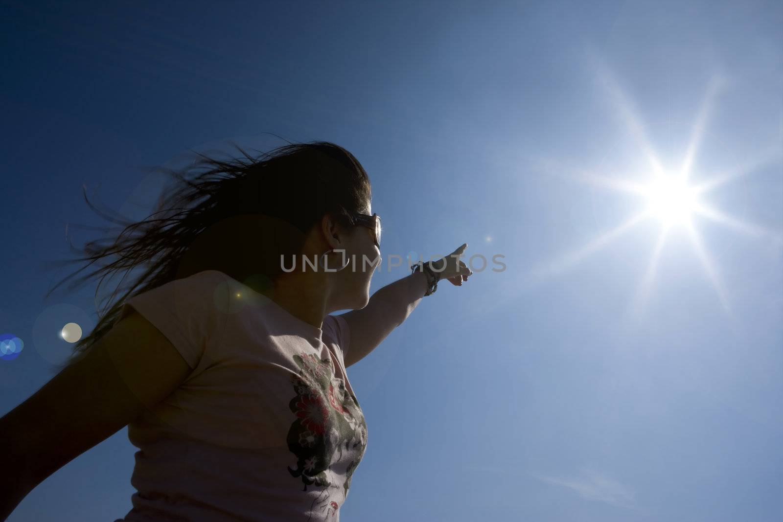 young woman pointing at the sun