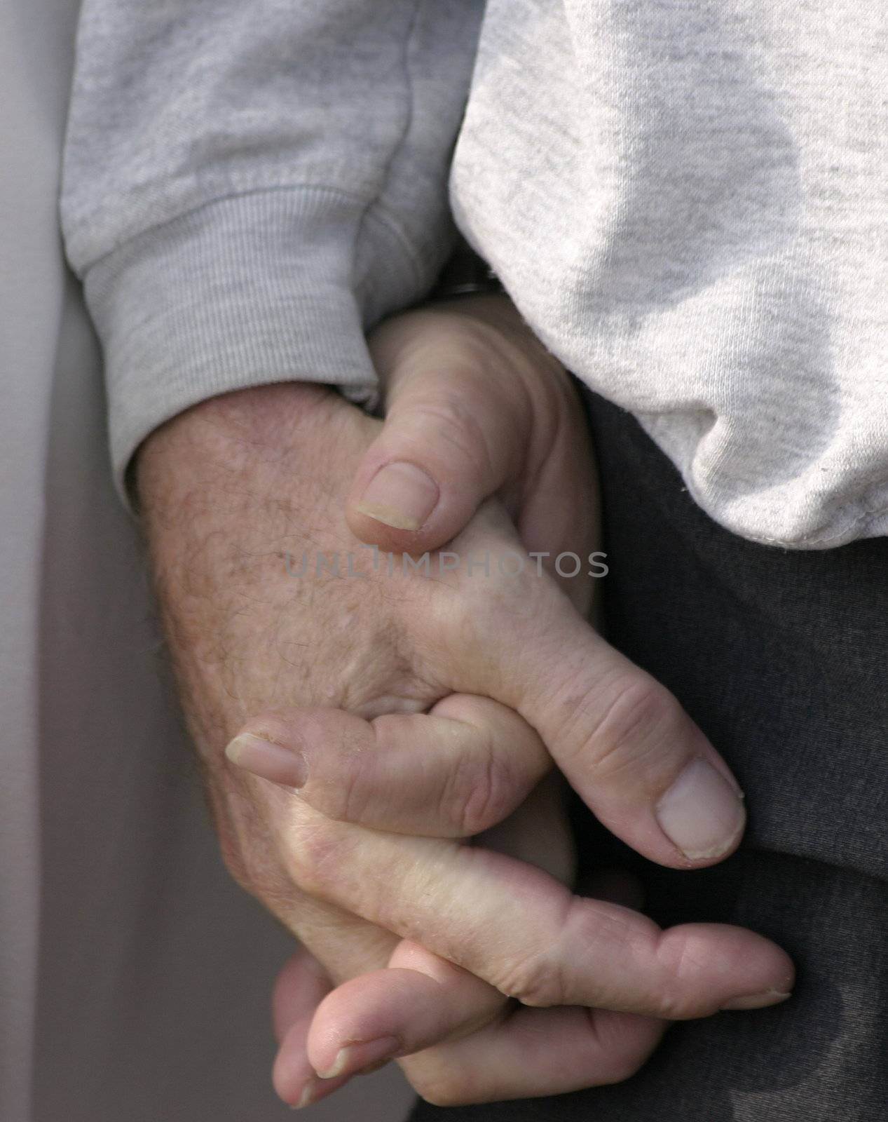 elderly couple holding hands whilst walking