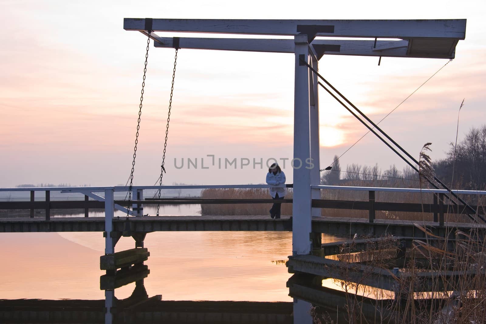 Old wooden lift-bridge in Dutch polderlandscape at sunset 