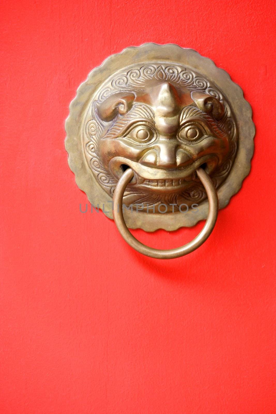 Image of an antique door knob on a bright red door.