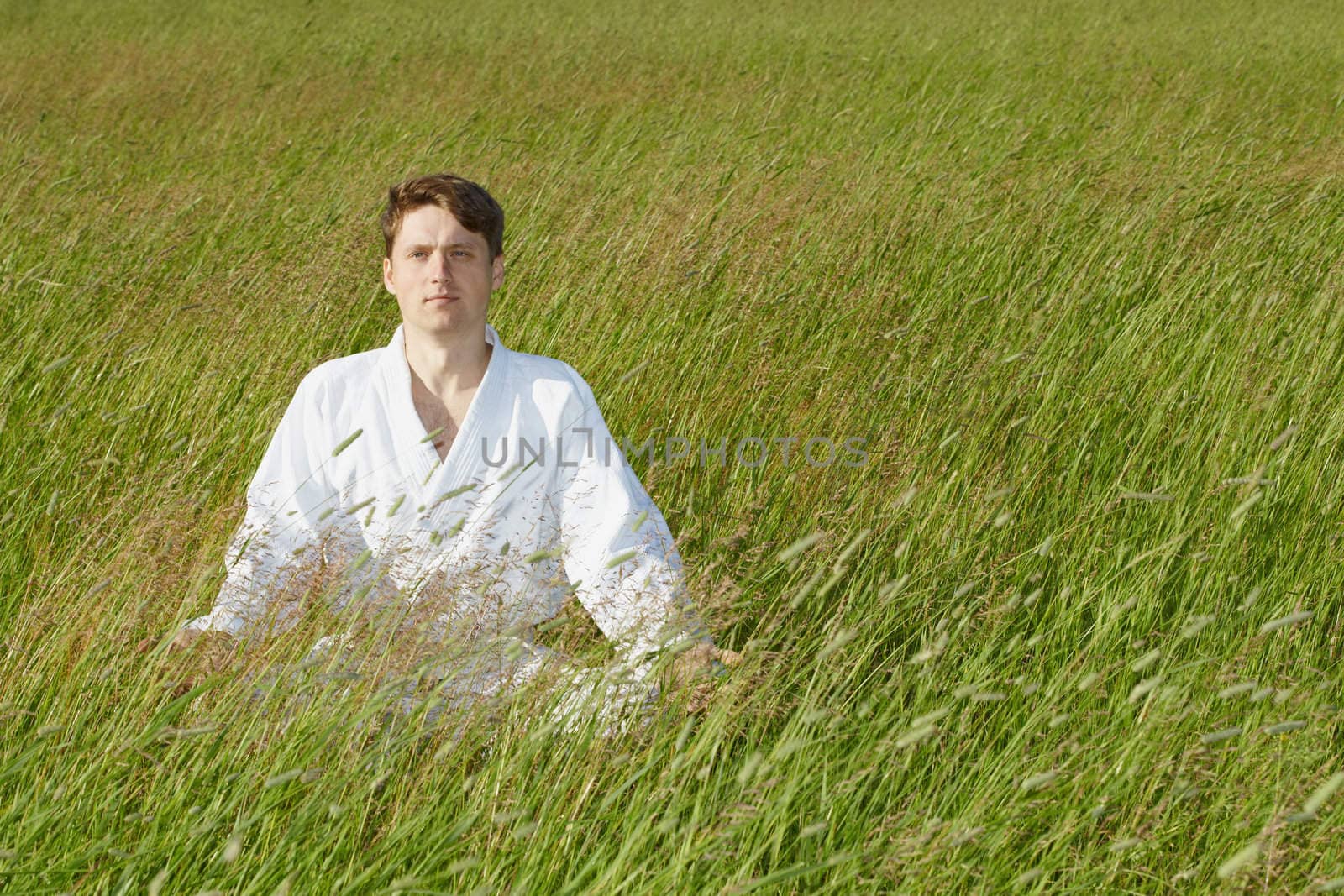 A man sits quietly in the grass