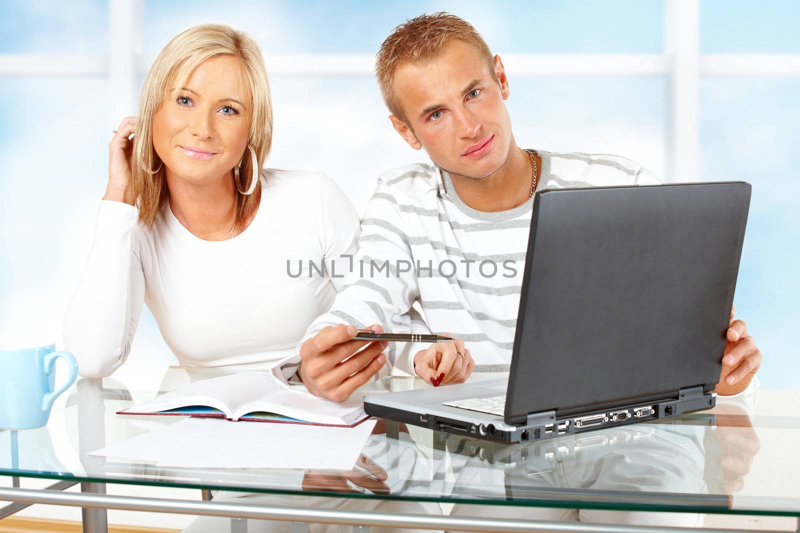 Portrait of a happy couple with laptop in home or office