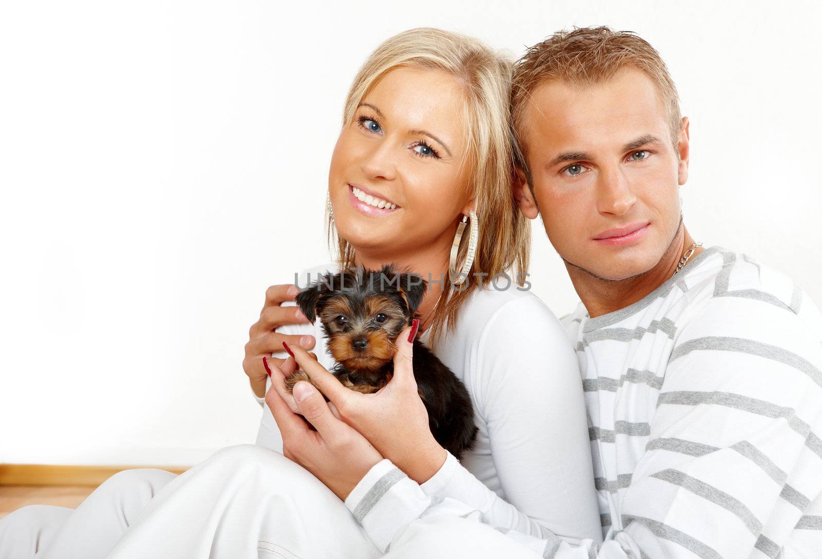 Happy couple with a funny puppy of Yorkshire Terrier