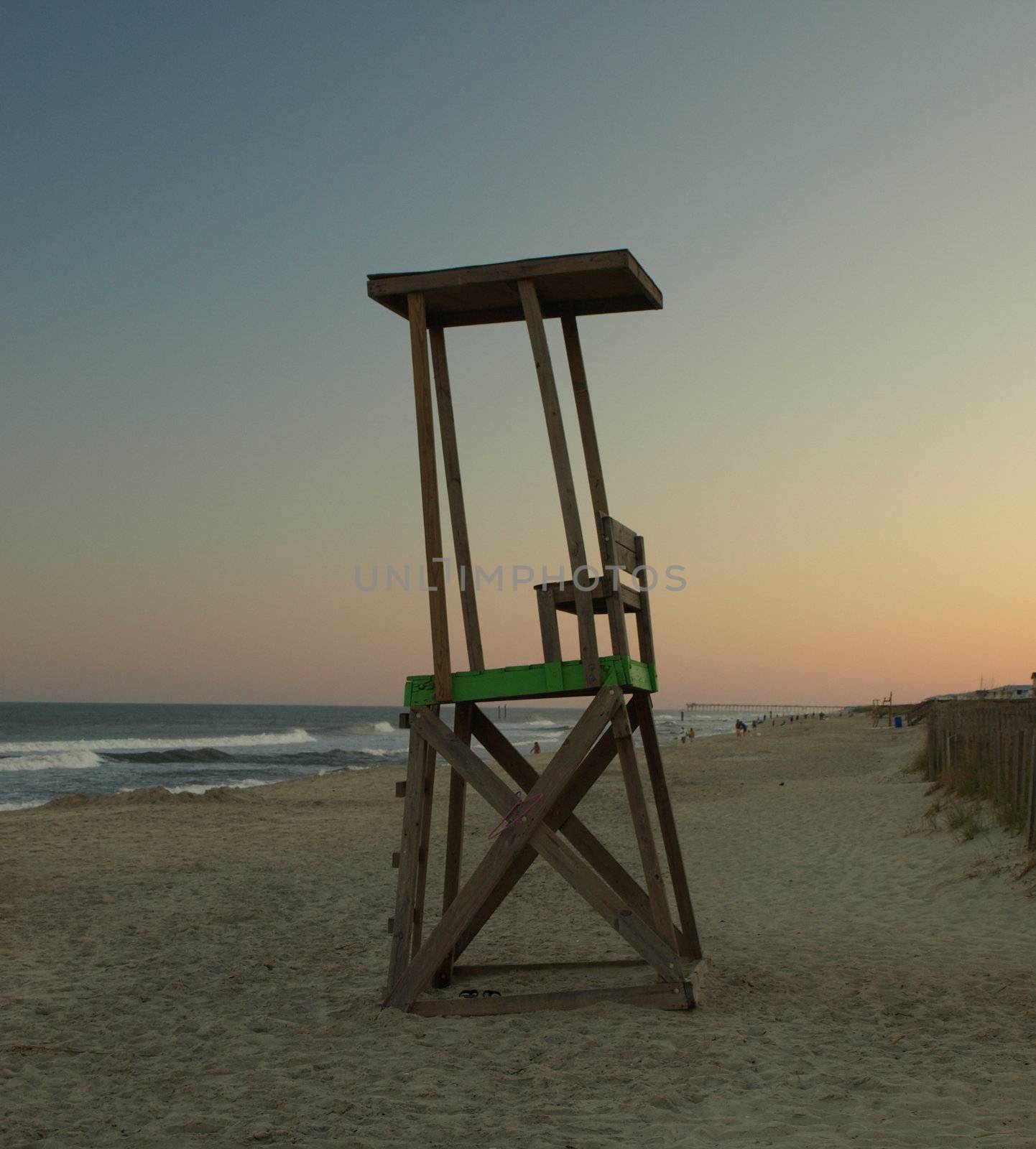 An empty lifegaurd chair at the end of a long summers day.