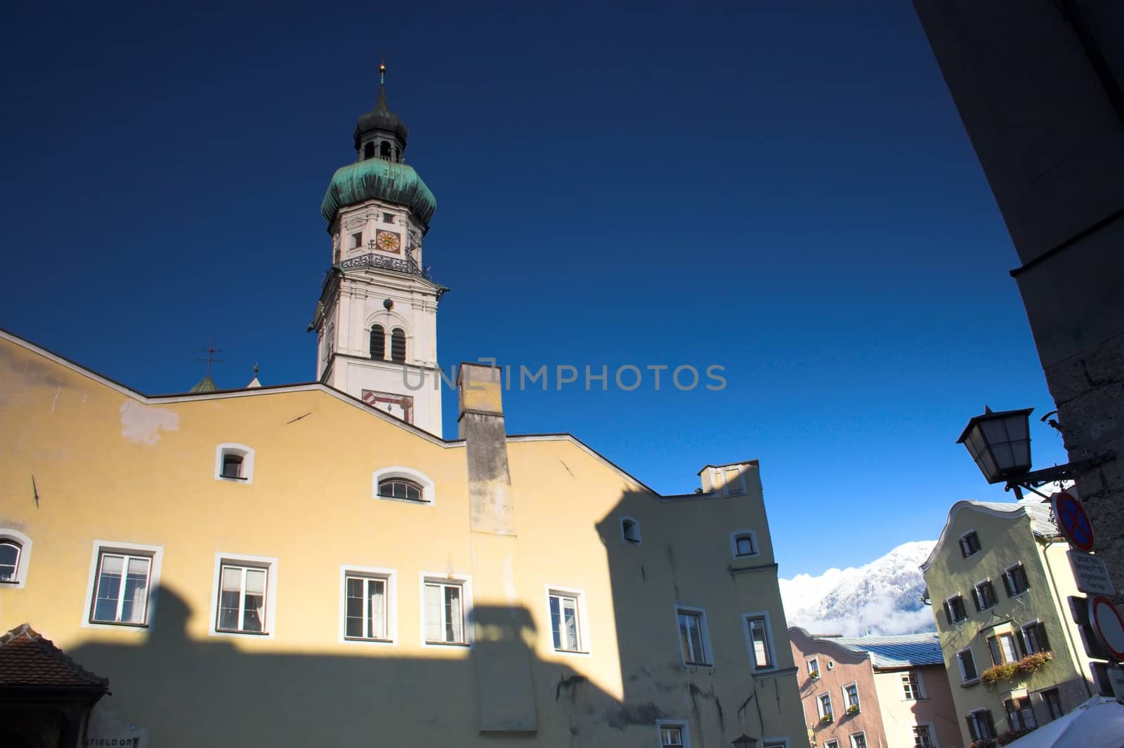 Yellow fa�ade of cathedral in Hall in Tirol and mountains