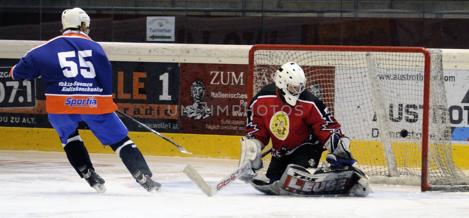 ZELL AM SEE, AUSTRIA - SEPTEMBER 30: Austrian Icehockey Classic Tournament. Tommi Aaltonen scores against Zell am See Goalie Peter Hochwimmer. Game Zell am See Oldies vs. Pallojussit (Result 3-3) on September 30, 2010 in Zell am See