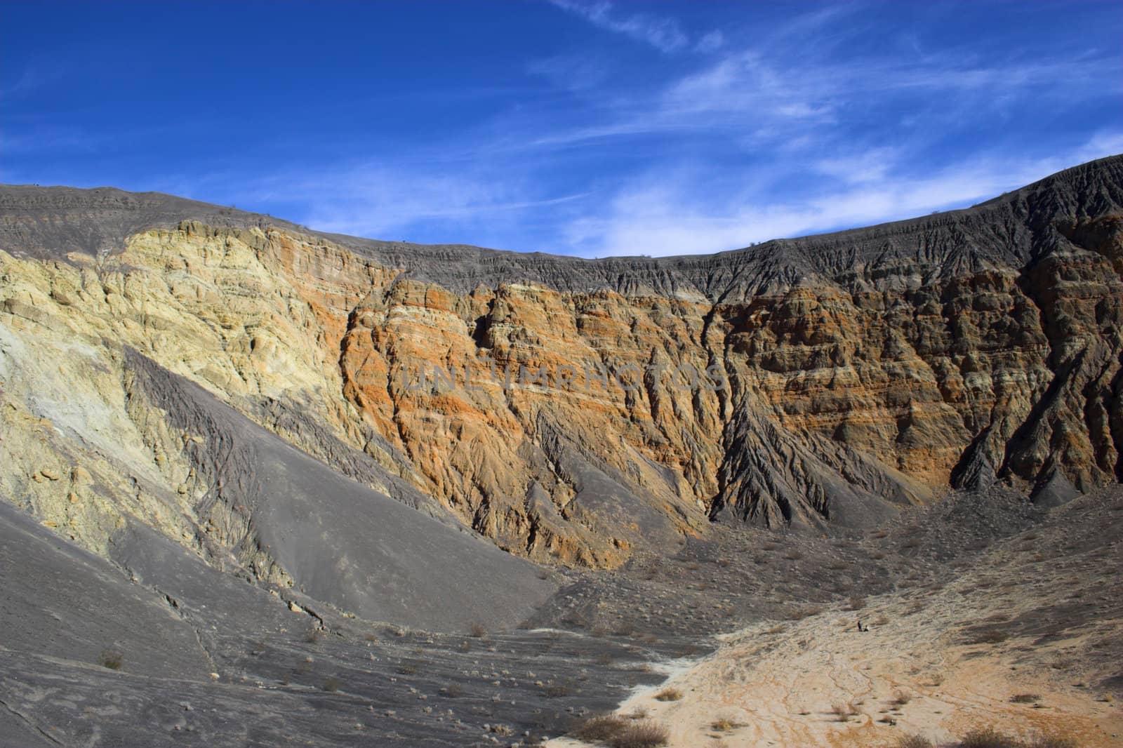 Fragment of black lava and ornage clay and salt mineral deposits in geological formations in Ubehebe Volcano, Death Valley National Park