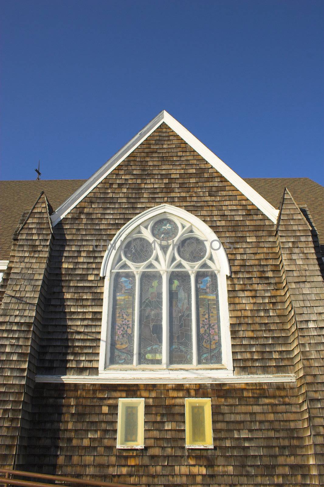 Fragment of historic wooden church with shingled walls and roof  