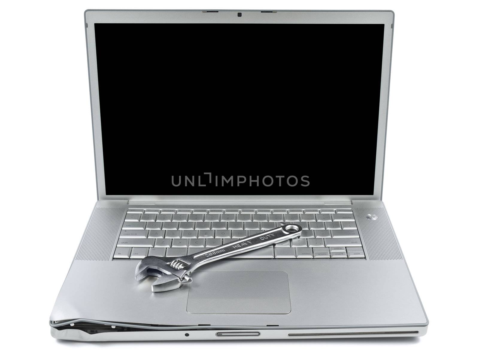 A spanner over a damaged laptop isolated over white background.