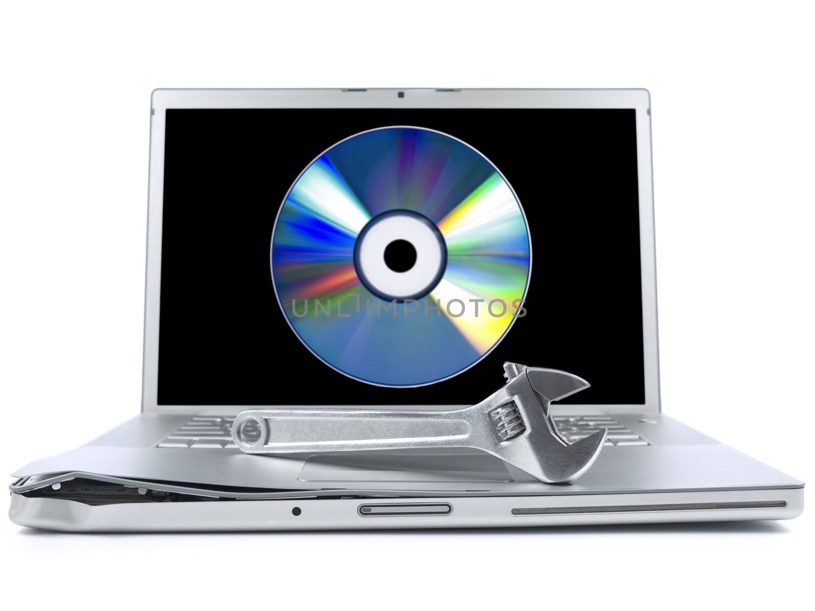 Damaged laptop with a spanner over it and a digital disc on the screen. Isolated on white.