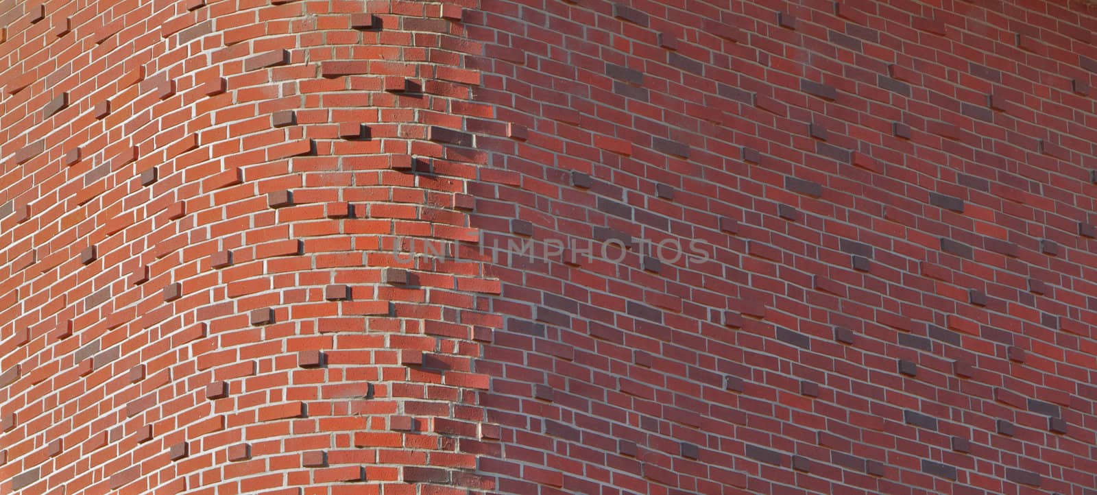 Tall red brick buidling with unusual round brick corner