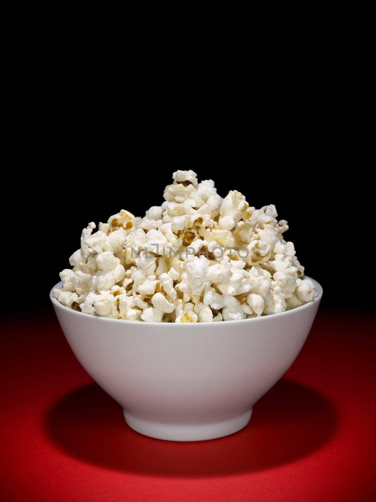 A bowl full of popcorn under the spotlight.