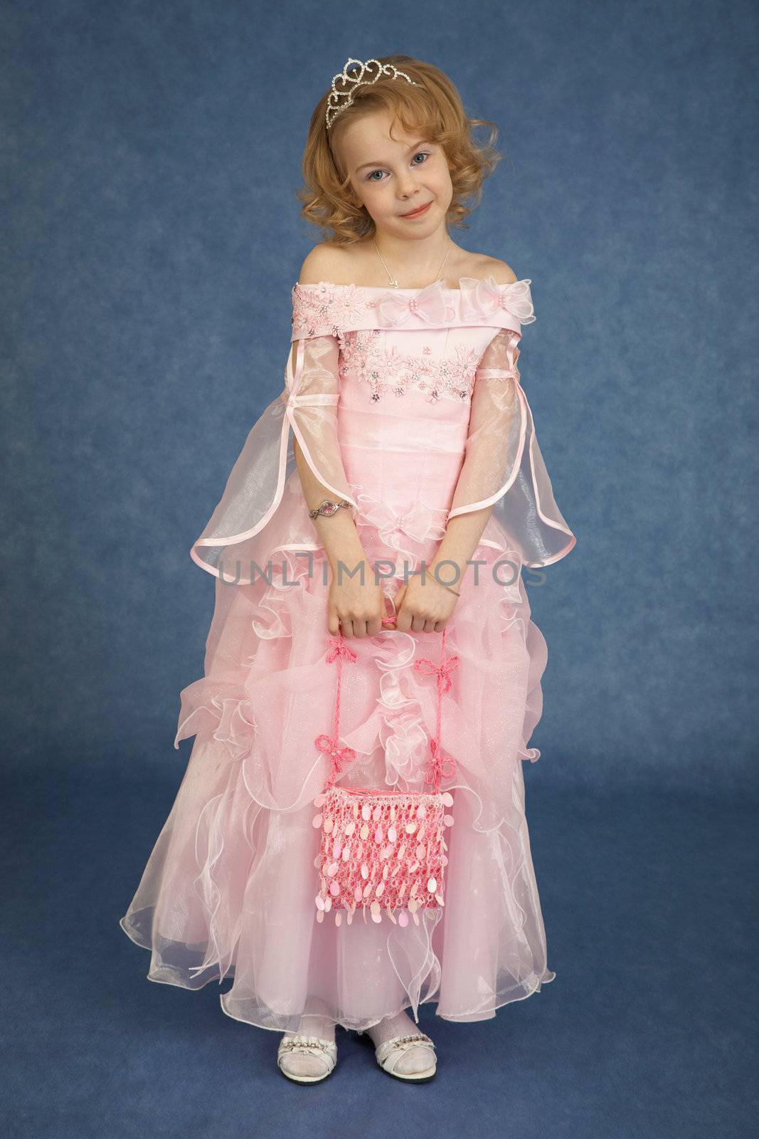 Little girl in pink dress stands on blue background by pzaxe