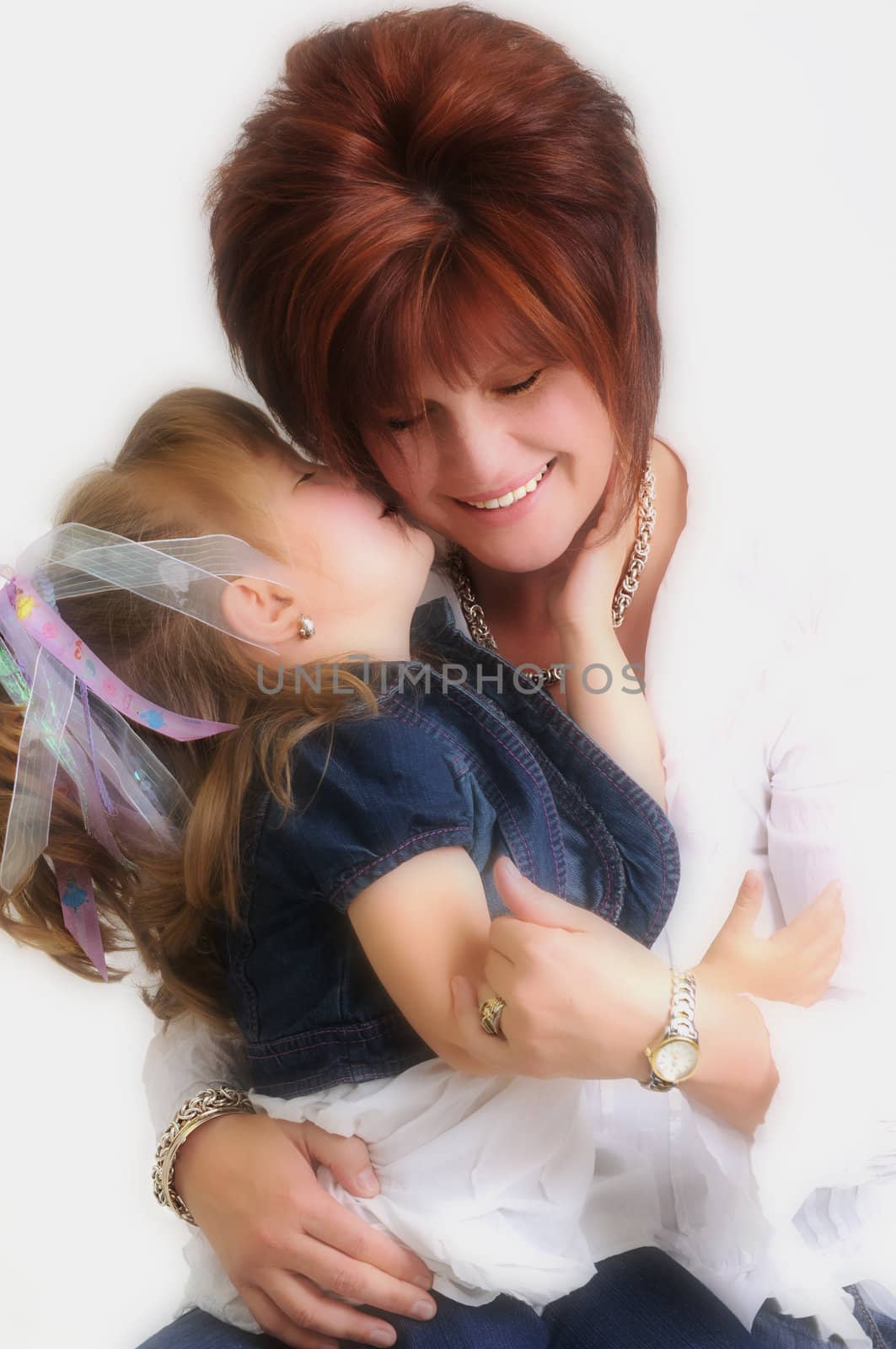 daughter kissing mother on the cheek and smiling