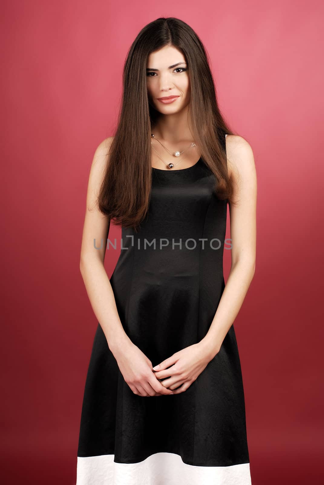 Model in studio on red background wearing dress.
