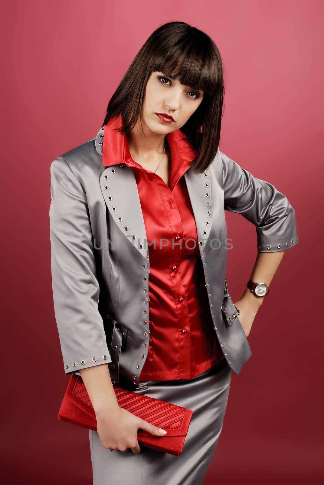 Model in studio on red background wearing business clothes.