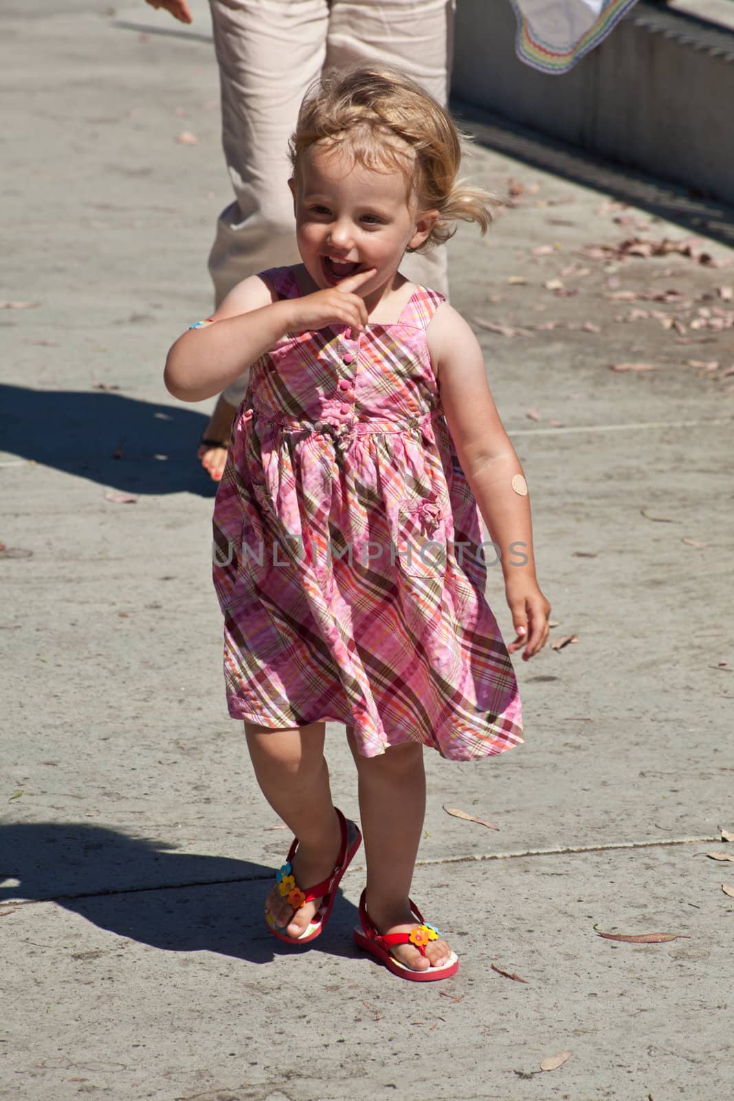 Cute little European toddler girl having fun at the playground in park