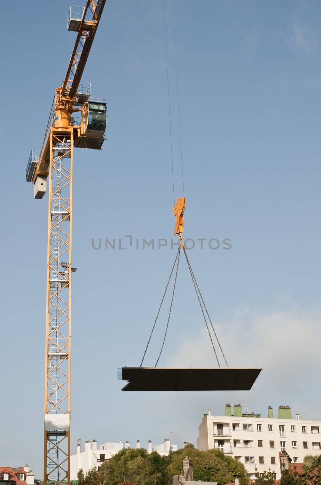 Yellow crane that carry a concrete plak