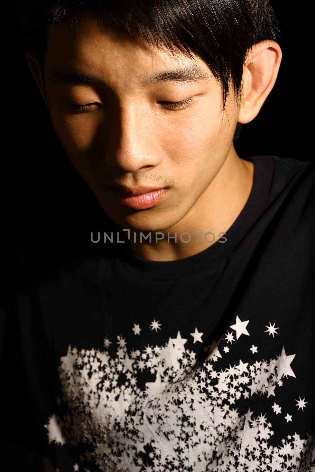 Troubled - Portrait of young handsome asia man close eyes in black.