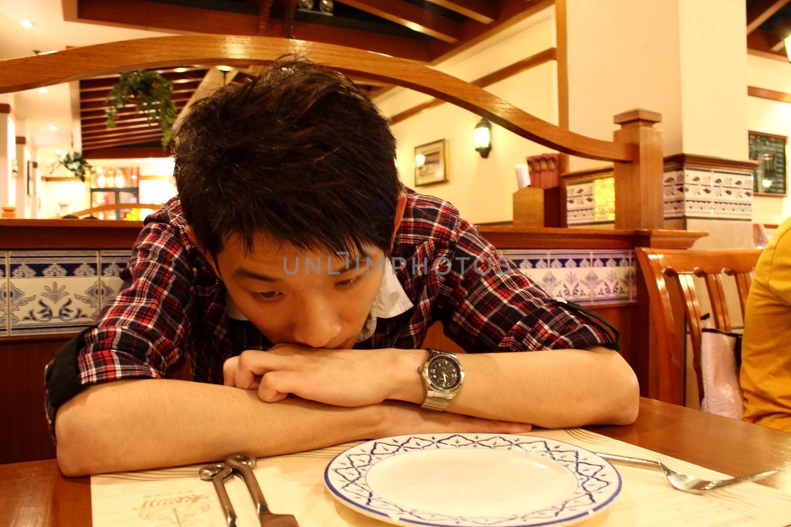 Portrait of a asia man bend on the table indoor