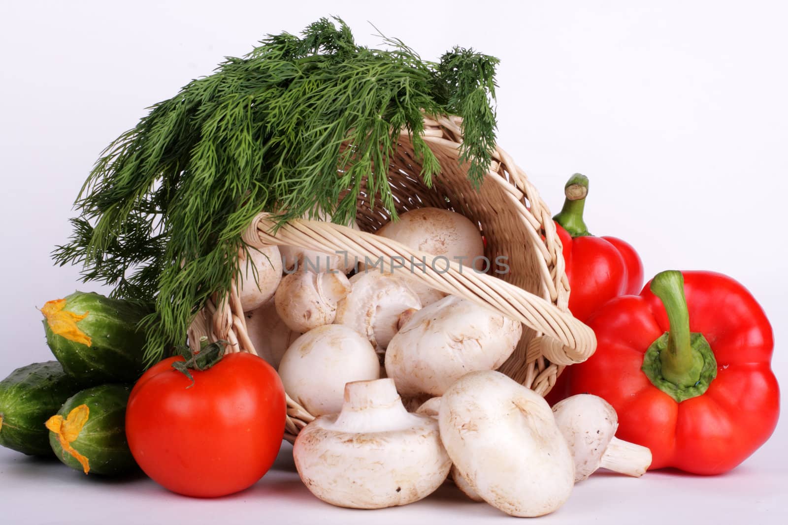 mushrooms, cucumbers, tomato and dill with basket on white by Dushenina