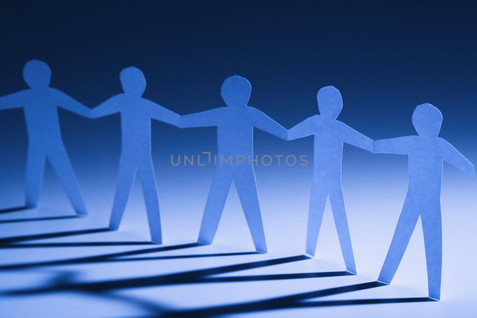 Paper cutout men standing holding hands.