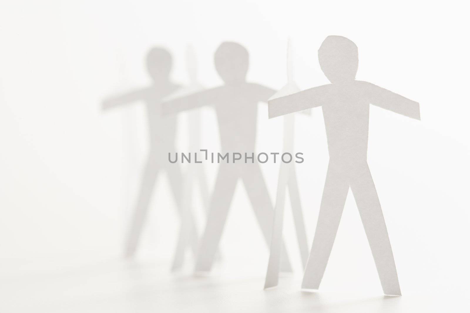 Cutout paper men standing holding hands.