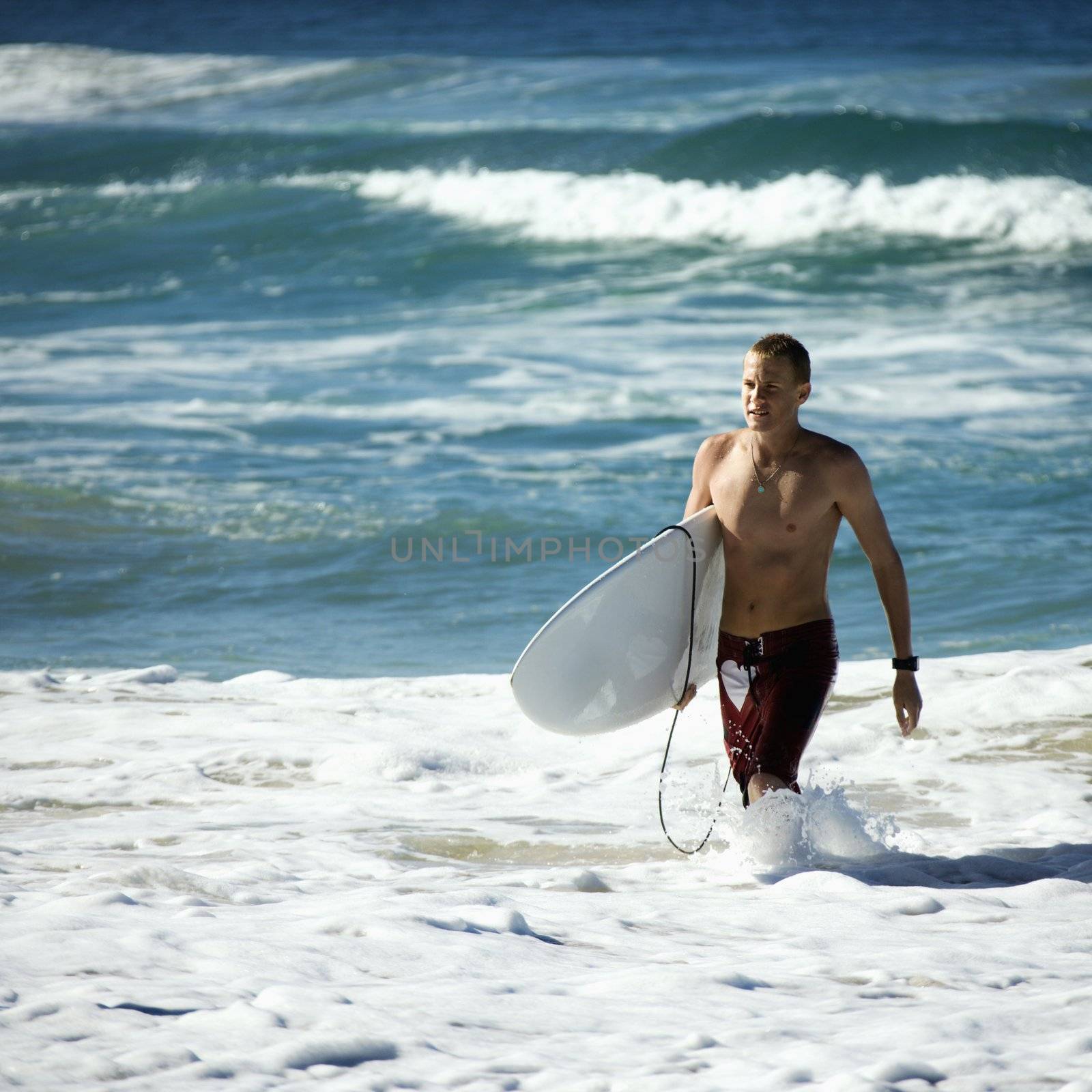 Teen surfer in water. by iofoto